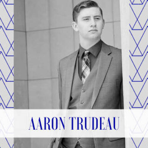 A professional-looking Black-and-white portrait of a young man in a suit and tie, facing slightly left with a confident and composed expression. The geometric patterned background is overlaid with a semi-transparent white band at the bottom.
